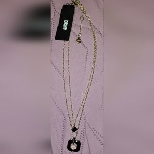 DKNY gold-tone layered necklace with a black square pendant and a tag.
